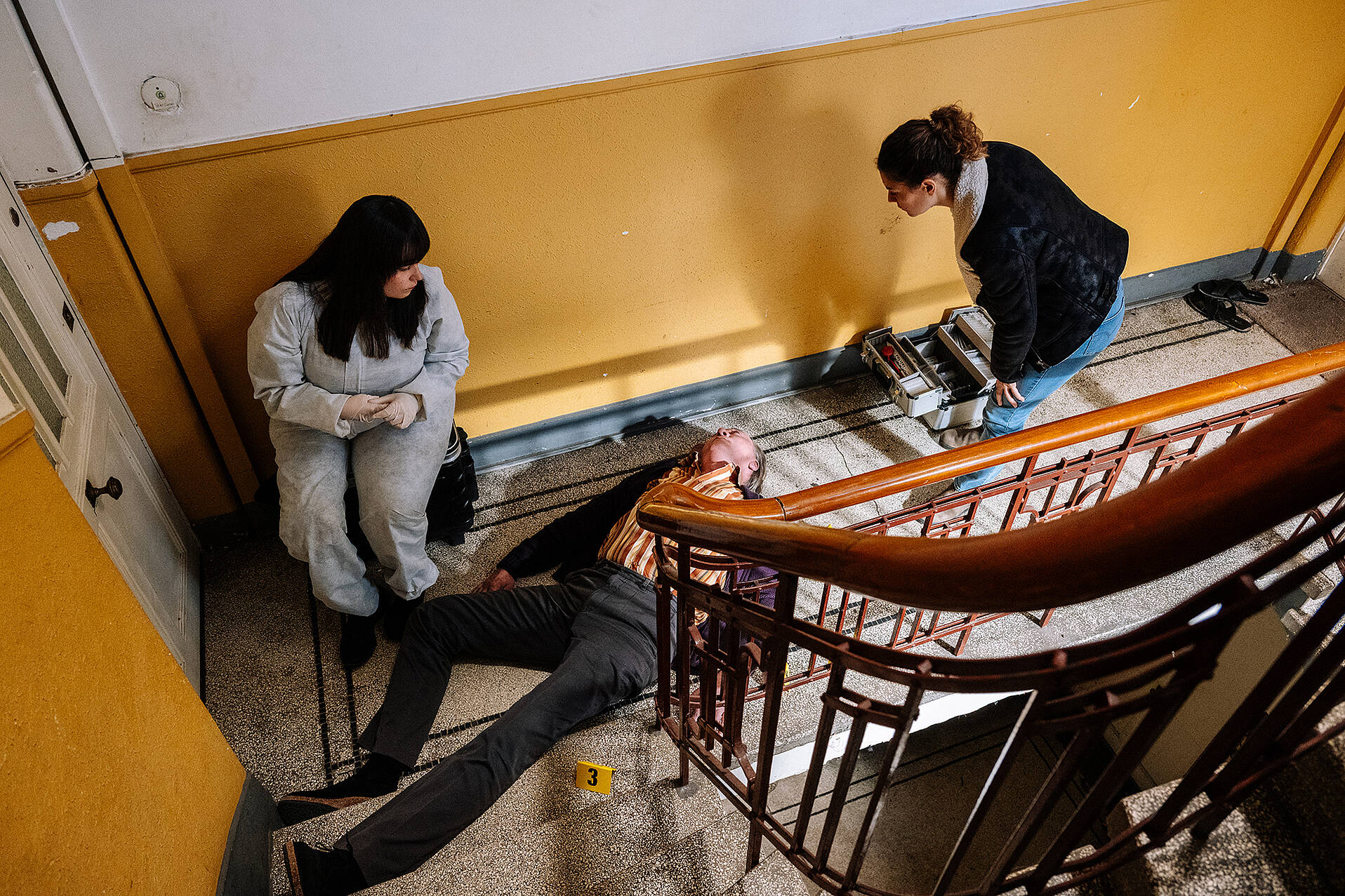 Rechtsmedizinerin Dr. Westphal (Yulia Yáñez Schmidt, l.) erklärt Kommissarin Lilly Funke (Tatjana Kästel, r.), dass der Tote, Wohnungseigentümer Peter Canapi (Stephan Böttcher, liegend), ermordet wurde (© ZDF/Martin Rottenkolber)